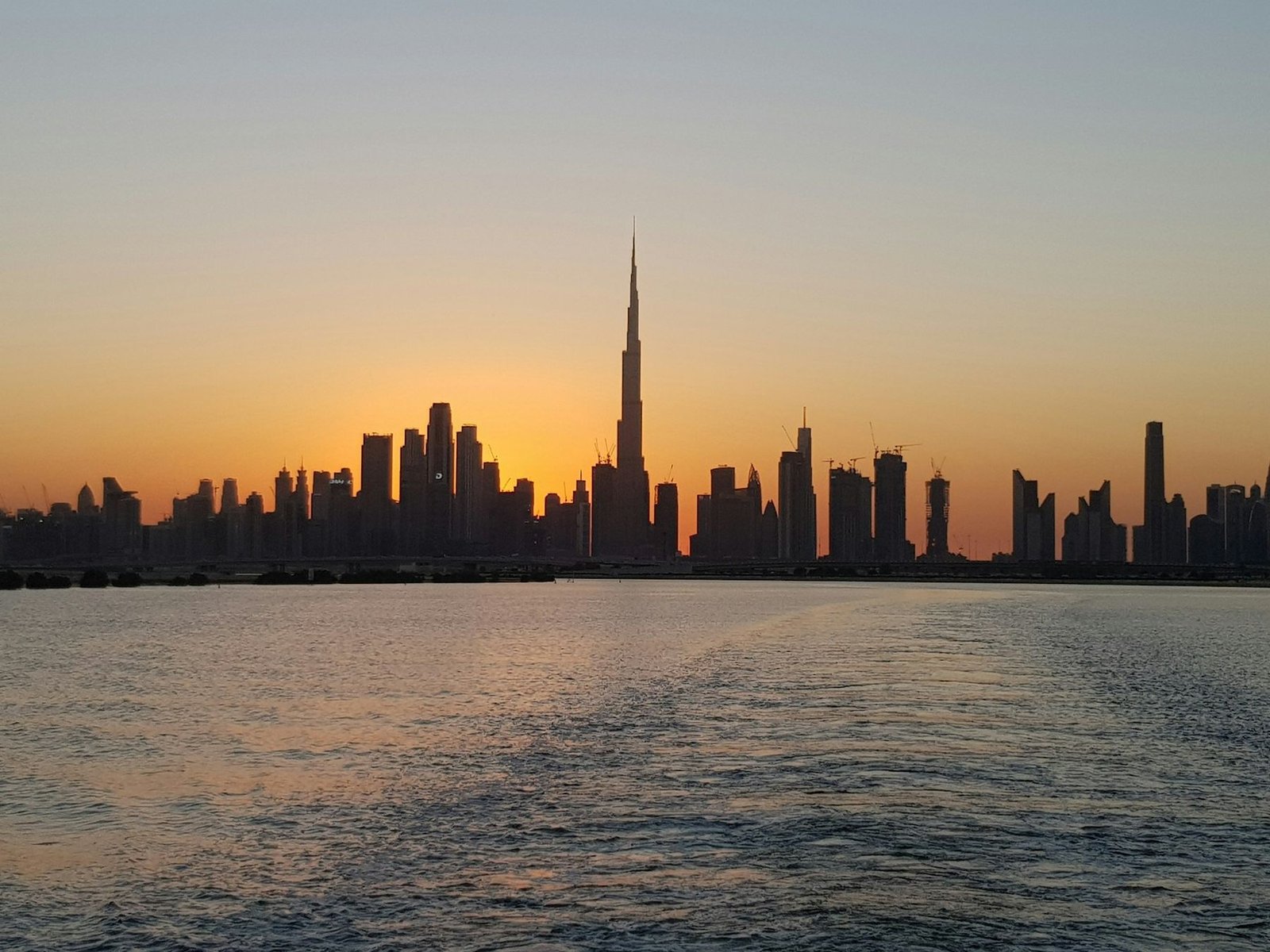 Dubai skyline with the Burj Khalifa across the water at sunset